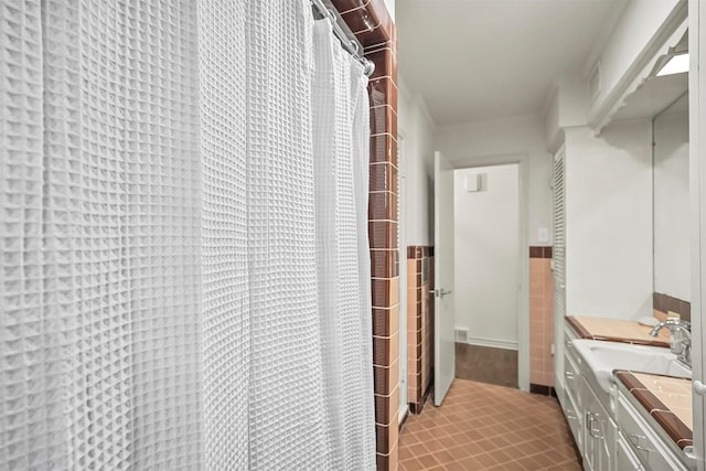 interior space featuring tile walls, tile patterned flooring, and vanity