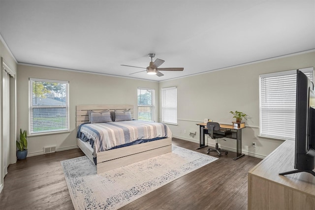 bedroom featuring dark wood-type flooring, multiple windows, and crown molding