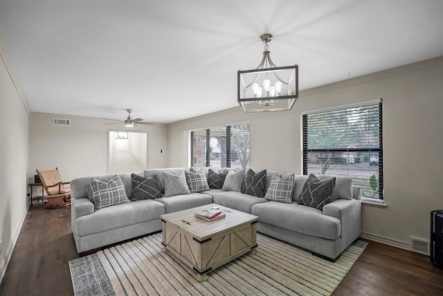 living area with ornamental molding, dark wood-style flooring, visible vents, and baseboards