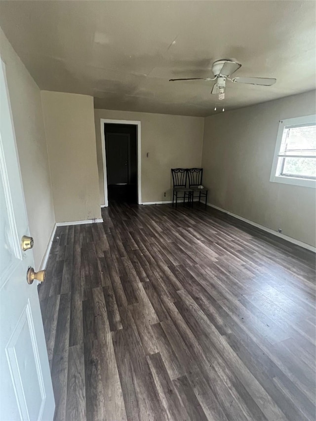 spare room featuring dark wood-style floors, baseboards, and a ceiling fan