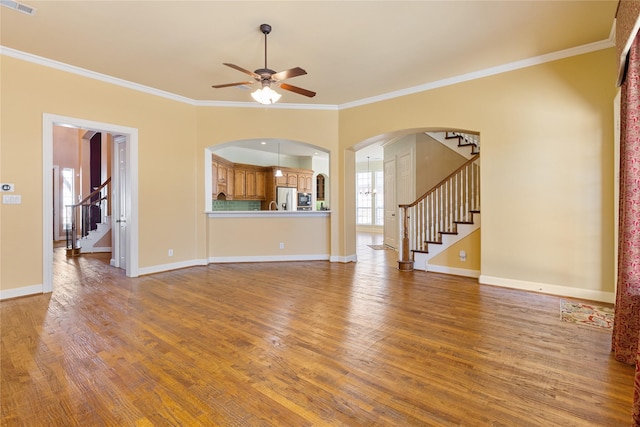 unfurnished living room featuring stairs, wood finished floors, and baseboards