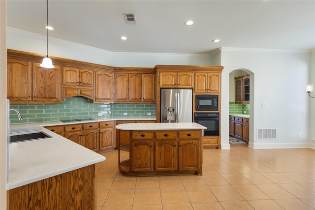 kitchen with a sink, black appliances, light countertops, and visible vents