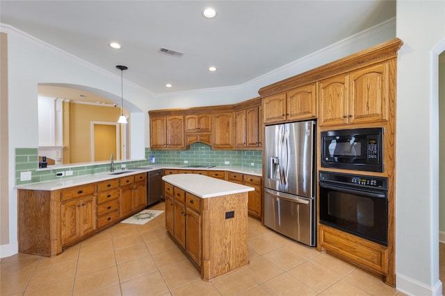 kitchen featuring visible vents, a kitchen island, light countertops, black appliances, and pendant lighting