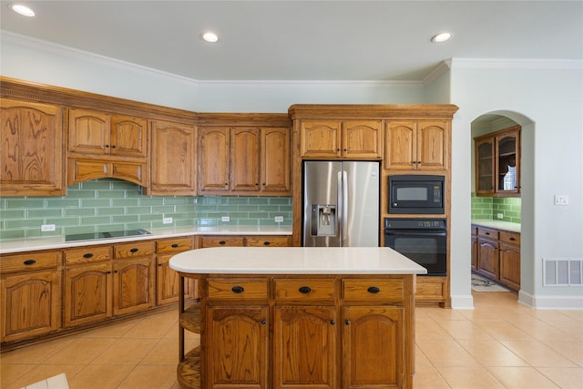 kitchen with light countertops, a center island, visible vents, and black appliances