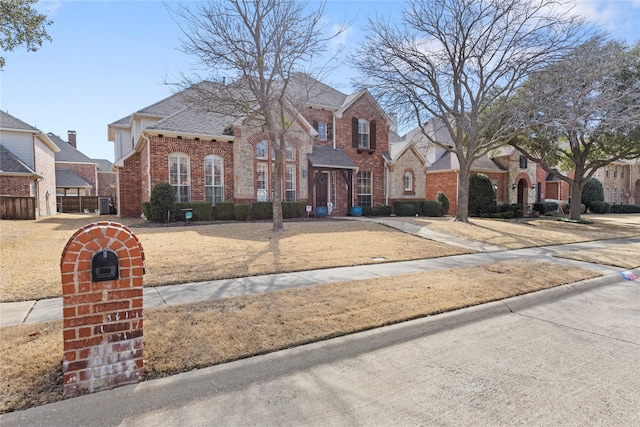 view of front of home with a shingled roof, a residential view, and brick siding