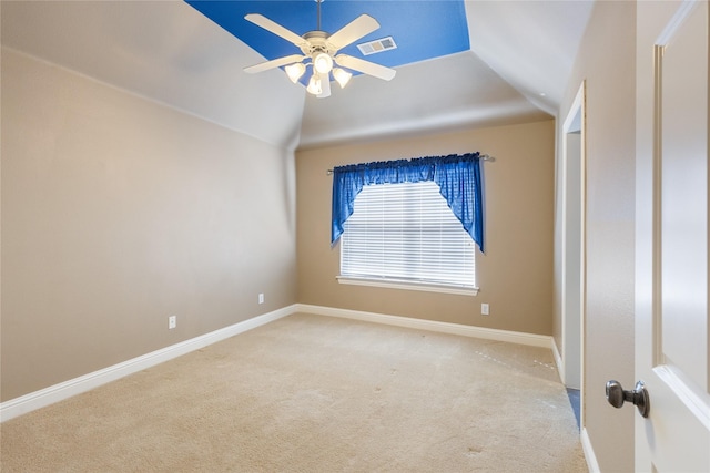 spare room with ceiling fan, light colored carpet, visible vents, baseboards, and vaulted ceiling