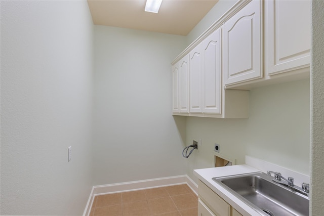 clothes washing area featuring cabinet space, baseboards, hookup for an electric dryer, a sink, and light tile patterned flooring