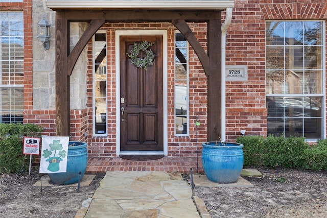 view of exterior entry featuring brick siding