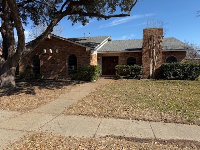 ranch-style house with brick siding and a front lawn