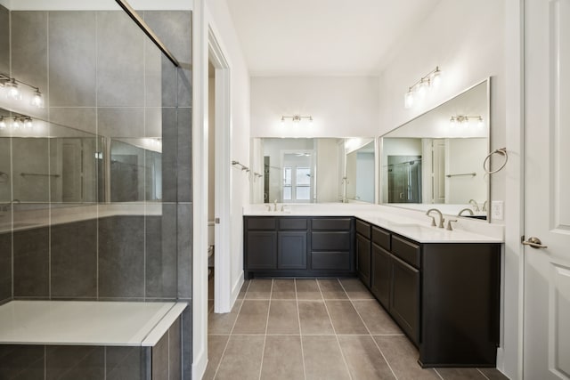 bathroom featuring a stall shower, tile patterned flooring, a sink, and double vanity