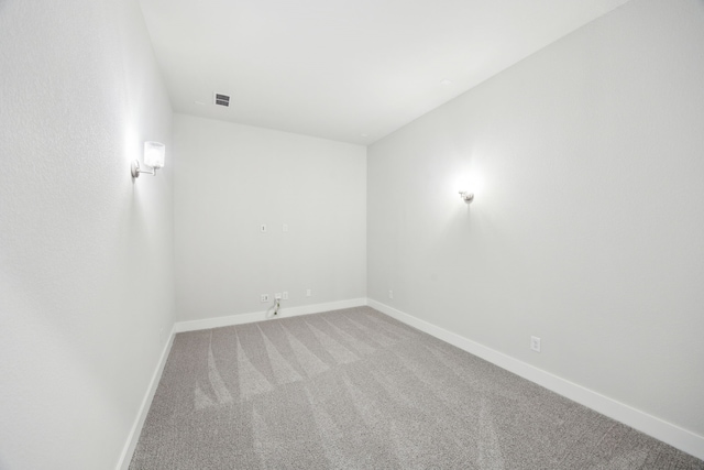 spare room featuring carpet flooring and baseboards