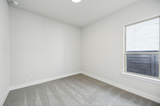 unfurnished room featuring carpet and baseboards