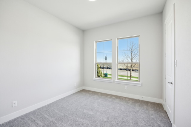 empty room featuring carpet and baseboards