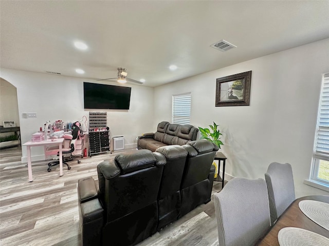 living area featuring arched walkways, light wood-type flooring, a ceiling fan, and recessed lighting