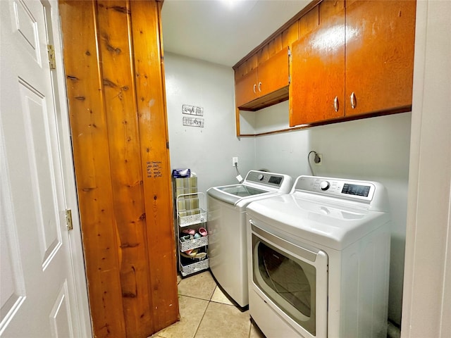 laundry area featuring light tile patterned flooring, cabinet space, and washer and dryer