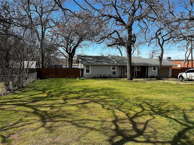 view of yard featuring a garage and fence