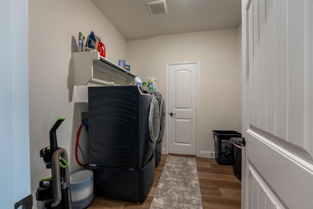 clothes washing area featuring laundry area, light wood finished floors, baseboards, visible vents, and washer and clothes dryer