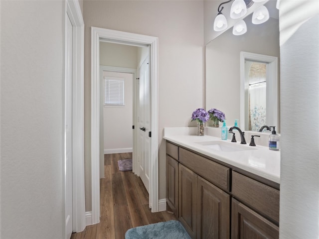 bathroom with vanity, baseboards, and wood finished floors