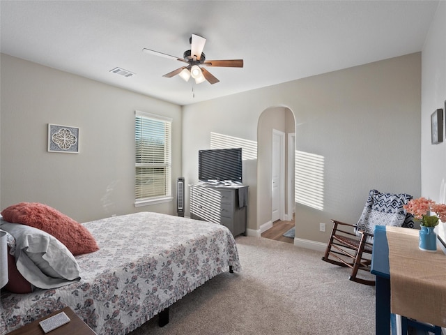 bedroom with arched walkways, carpet, visible vents, ceiling fan, and baseboards