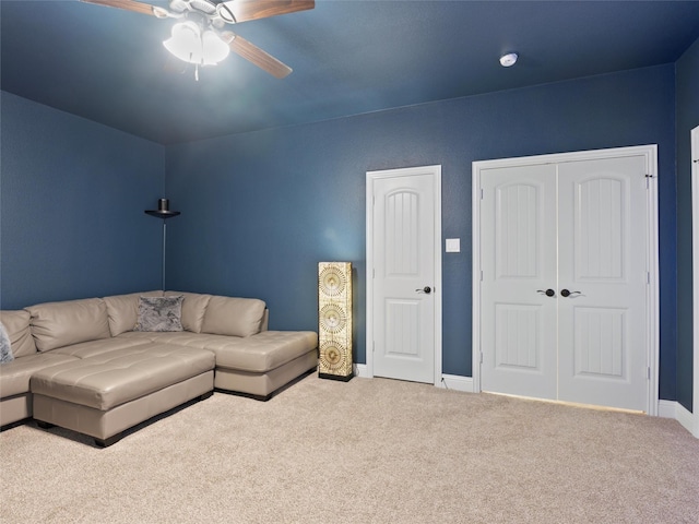 carpeted living room featuring a ceiling fan and baseboards