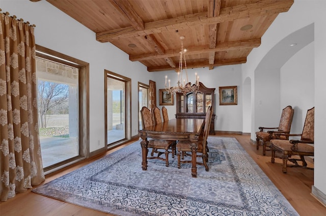 dining area featuring arched walkways, wood finished floors, wood ceiling, and a chandelier