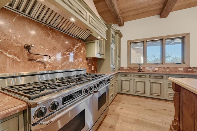 kitchen featuring light countertops, backsplash, double oven range, wall chimney exhaust hood, and beamed ceiling