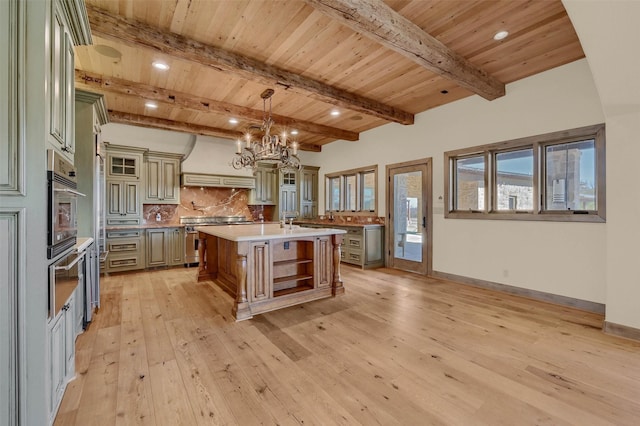 kitchen with custom range hood, glass insert cabinets, decorative light fixtures, a kitchen island with sink, and open shelves