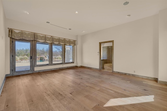 spare room with light wood-type flooring and baseboards