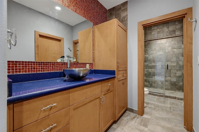 bathroom featuring a shower stall, vanity, and toilet