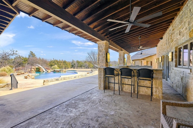 view of patio featuring an outdoor pool, outdoor dry bar, and a ceiling fan