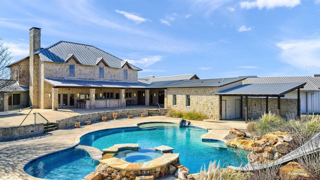 view of swimming pool with exterior bar, a patio area, and a pool with connected hot tub