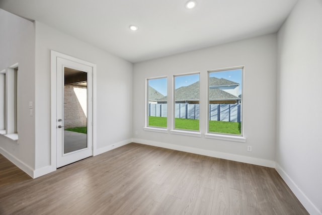 empty room featuring recessed lighting, wood finished floors, and baseboards