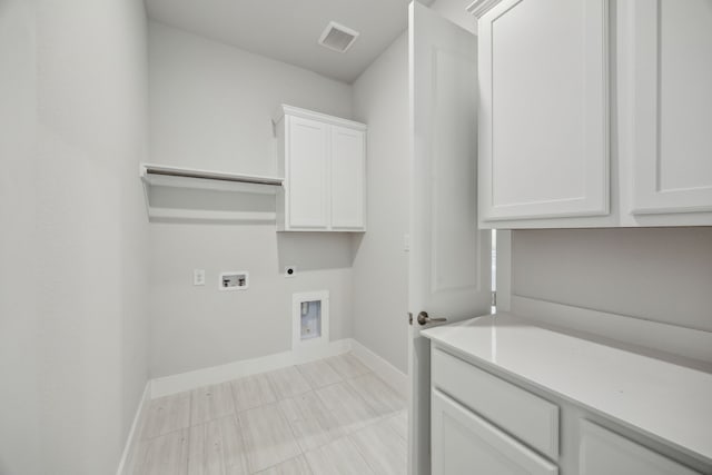 clothes washing area with washer hookup, visible vents, cabinet space, electric dryer hookup, and baseboards