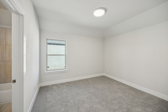 carpeted spare room featuring baseboards