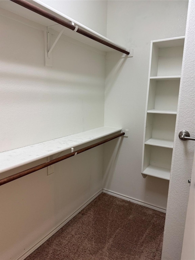 spacious closet featuring dark carpet