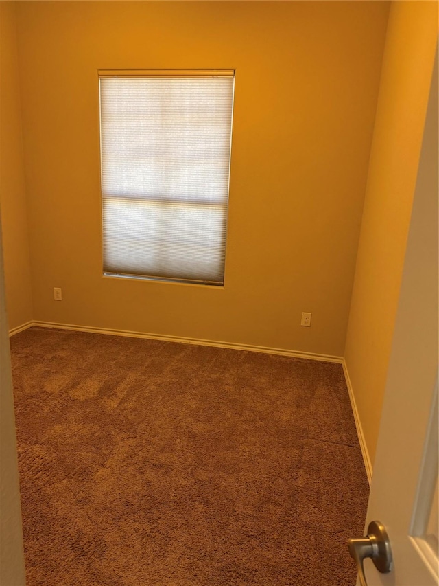 unfurnished room featuring carpet floors and baseboards