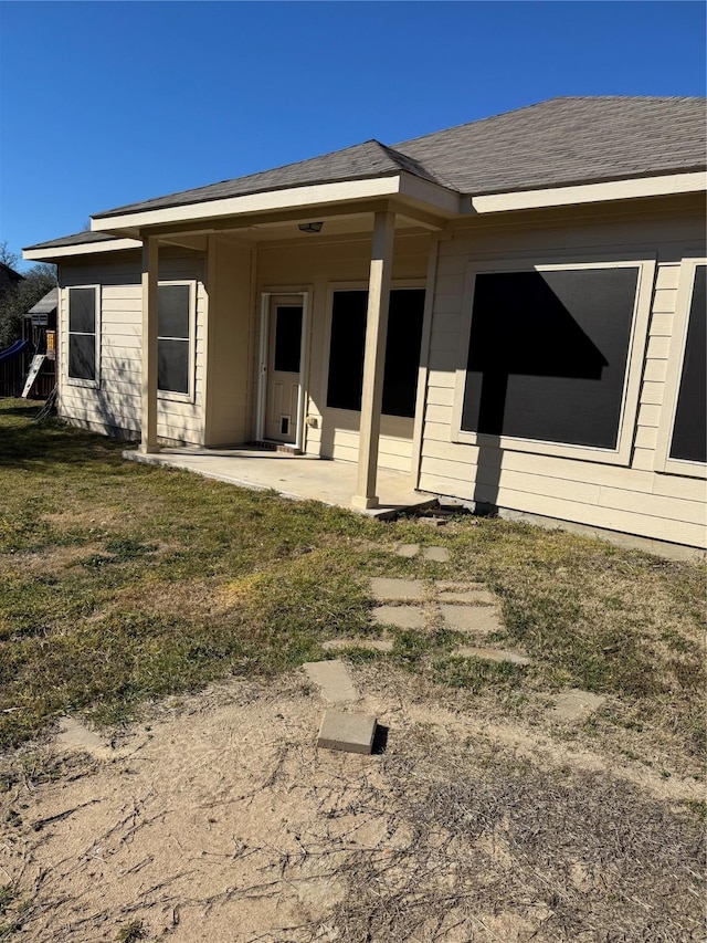 back of property featuring a lawn and a patio