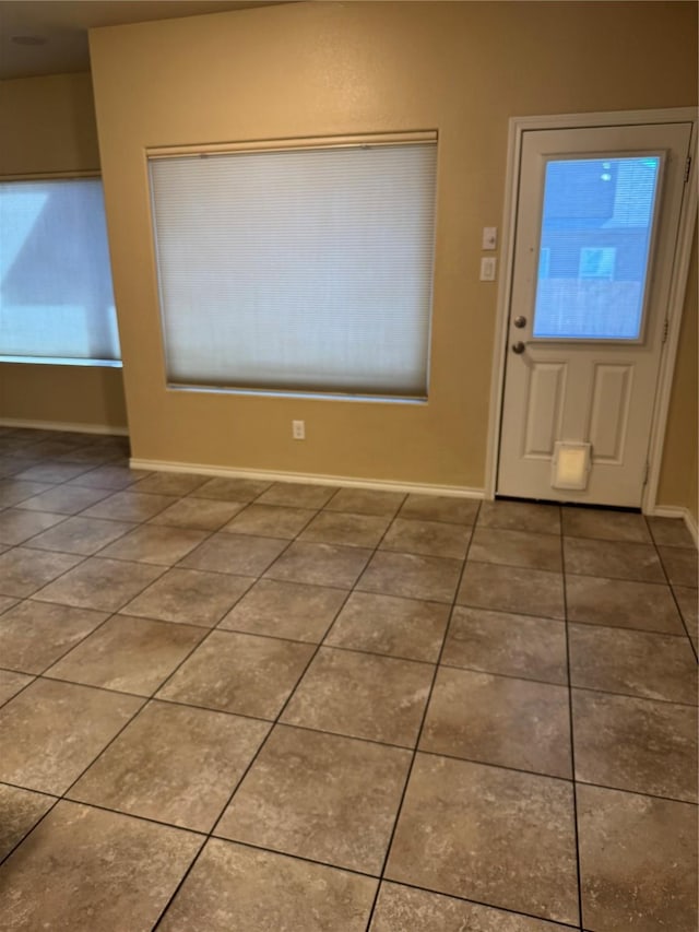 foyer featuring tile patterned flooring and baseboards