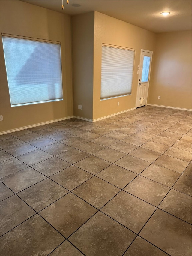 spare room with tile patterned floors and baseboards