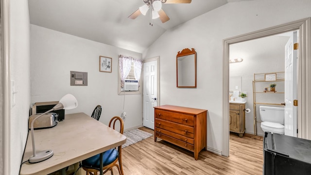 home office featuring a ceiling fan, vaulted ceiling, and light wood-style flooring