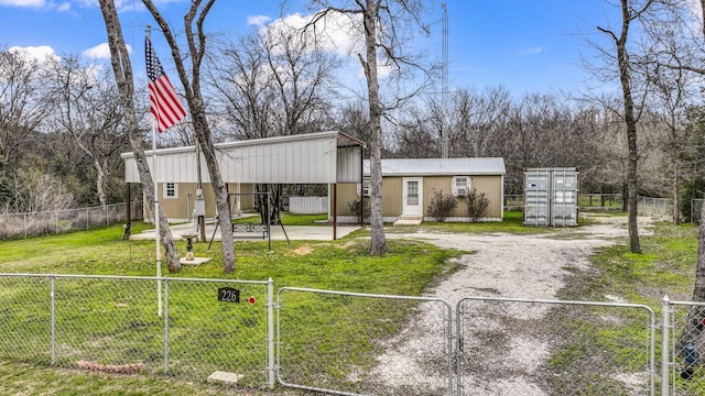 view of front of home with a fenced front yard, a gate, a front lawn, and gravel driveway