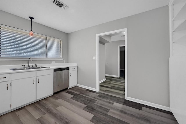 kitchen featuring white cabinets, pendant lighting, stainless steel dishwasher, and light countertops