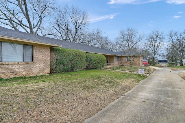 ranch-style house with brick siding, fence, and a front lawn