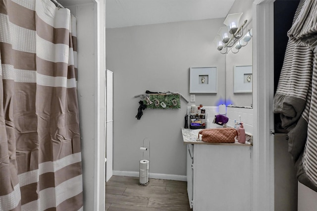 bathroom featuring baseboards, wood finish floors, and vanity