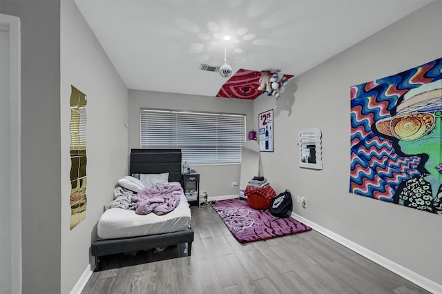 bedroom featuring visible vents, baseboards, and wood finished floors