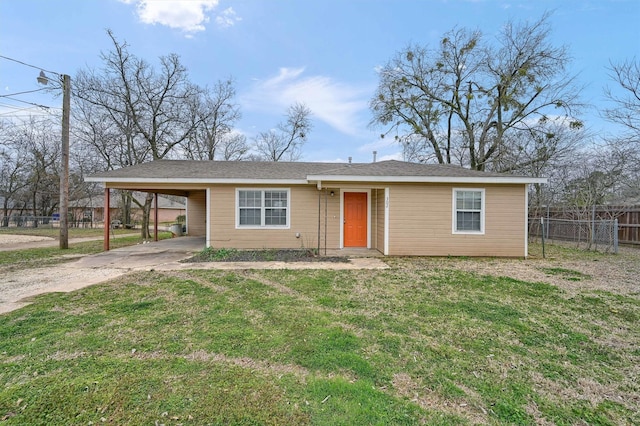 view of front facade with driveway, an attached carport, a front yard, and fence