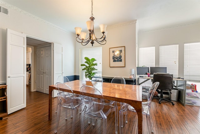 dining area featuring dark wood-style floors, visible vents, a notable chandelier, and ornamental molding