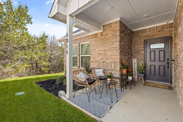 entrance to property featuring brick siding and a yard