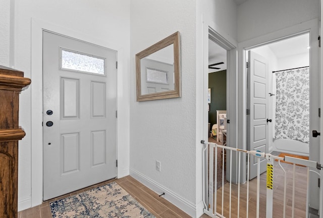 entryway with wood tiled floor and baseboards