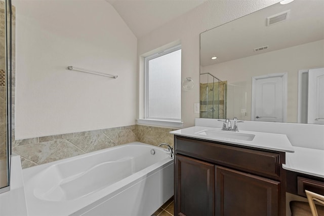 bathroom featuring a bath, a stall shower, vanity, and visible vents